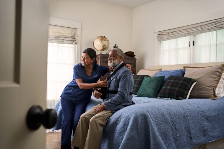 A caregiver adjusts a client's arm sling