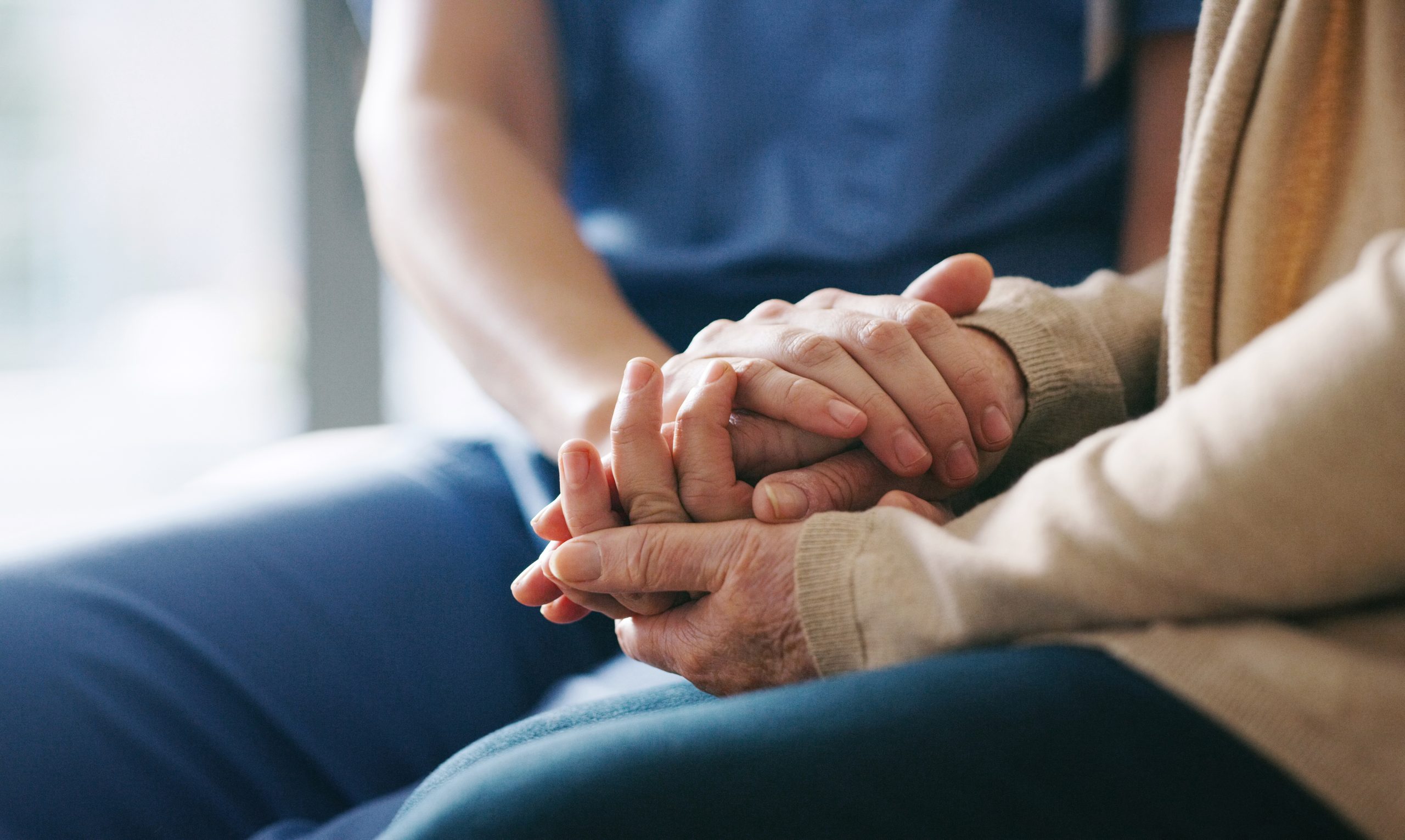 SYNERGY HomeCare client and caregiver holding hands
