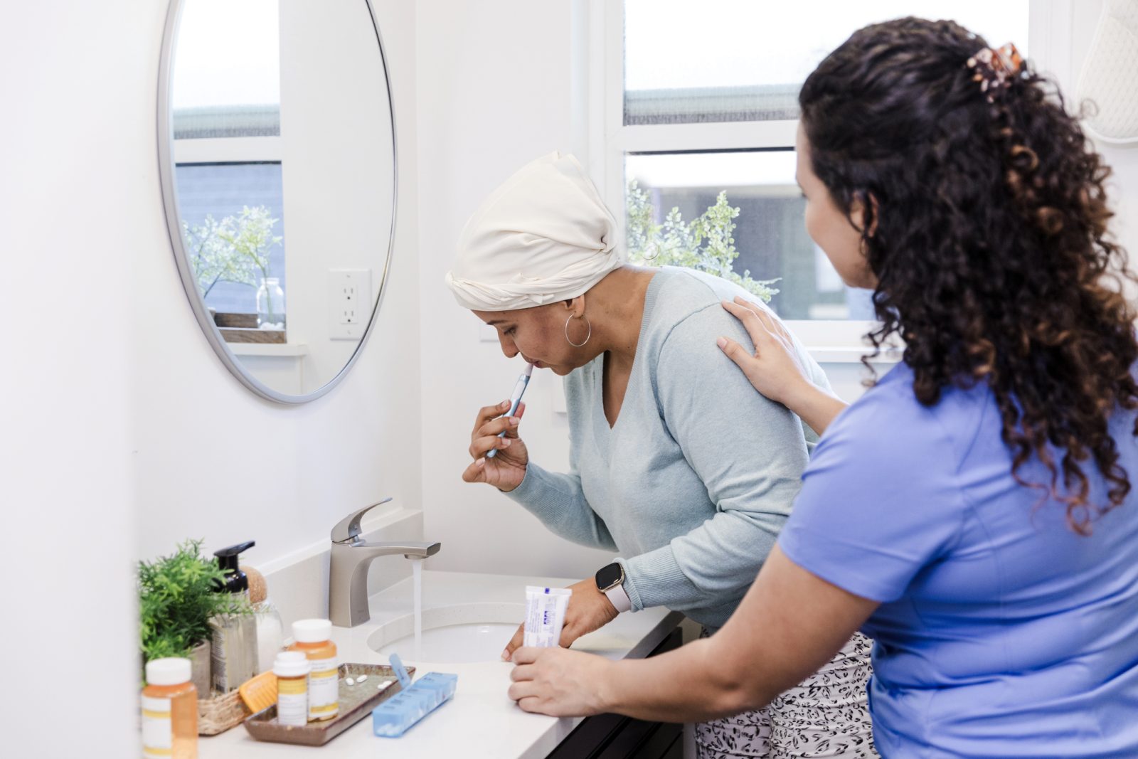 SYNERGY HomeCare caregiver helping Alzheimer's client brush teeth.