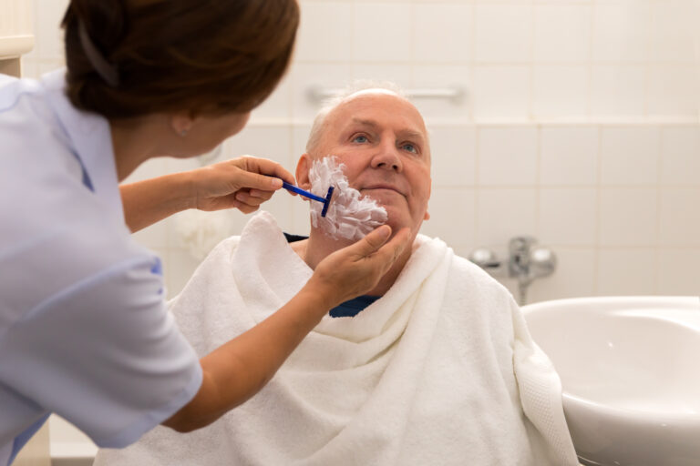 Personal hygiene – home caregiver with senior man in bathroom
