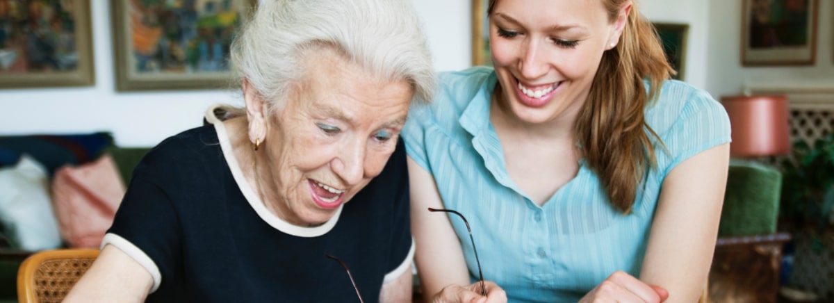 woman and senior woman enjoying doing a crossword puzzle together