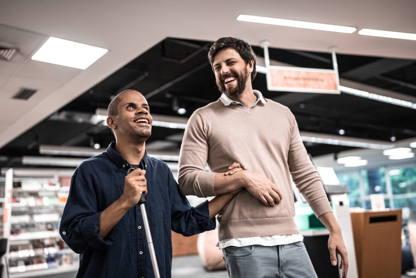 Middle-aged adult man who is visually impaired talking and smiling with friend