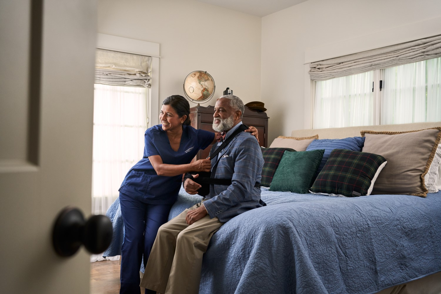 SYNERGY HomeCare caregiver helping client get dressed
