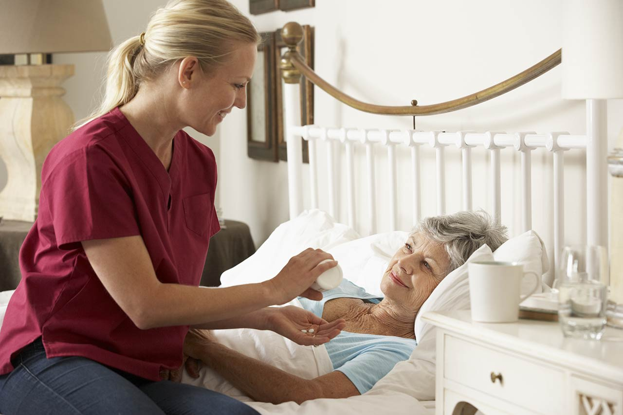 SYNERGY HomeCare caregiver helping client take medication