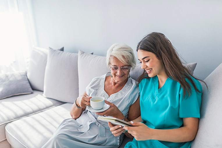 female caregiver sitting on couch with client talking