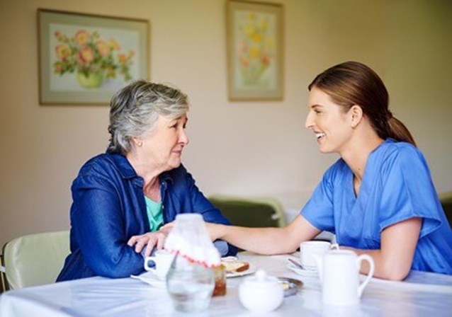 senior with caregiver eating