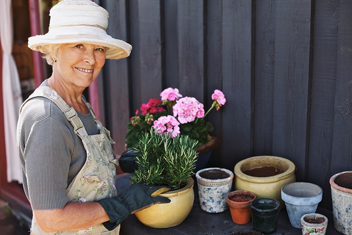 happy senior woman planting flowers